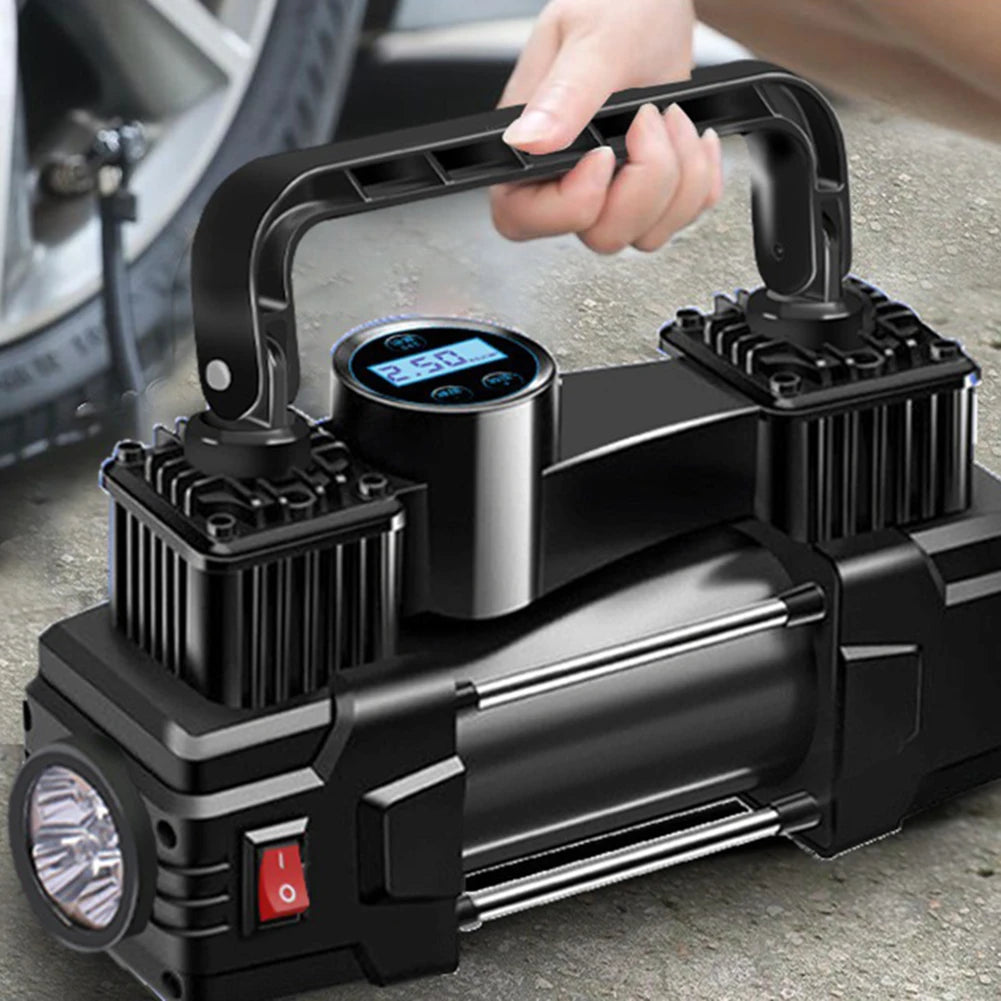 Black portable air compressor with digital display held by a hand, with a car tire in the background.