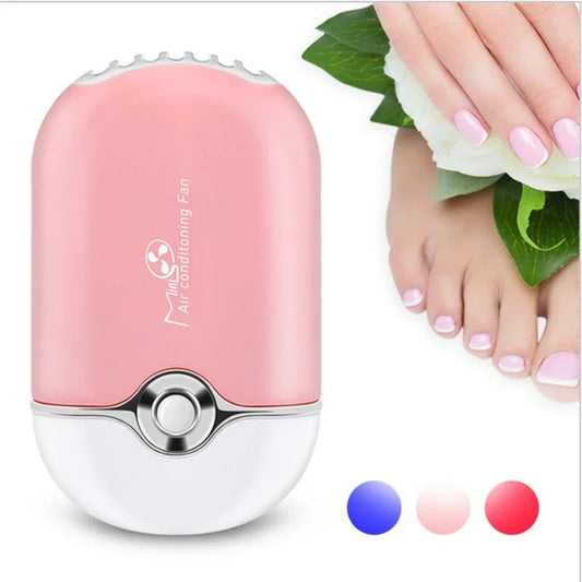 Pink handheld air conditioning fan with a hand holding flowers in the background