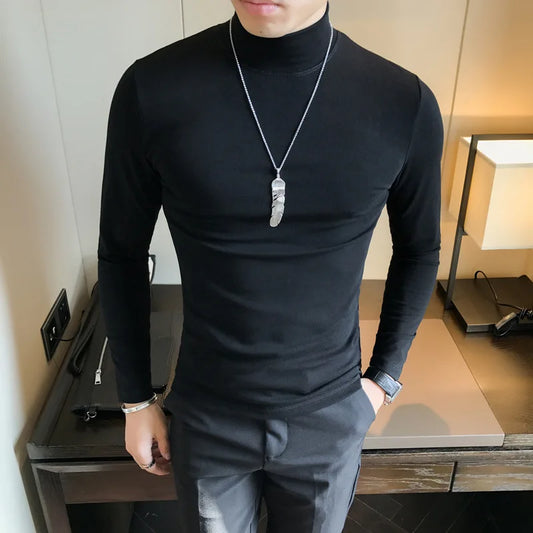 Person wearing a black turtleneck and gray pants indoors.